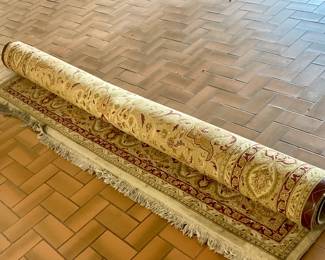 Large rug rolled up, fringe is soiled
