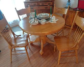 Round solid oak dining table with four matching chairs and leaf