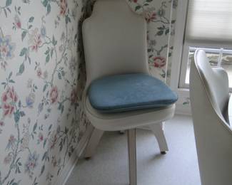 Closer  look of one of the chairs, that has Formica legs, and vinyl upholstery 