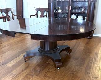 An antique mahogany American Empire revival style pedestal dining table with three leaves