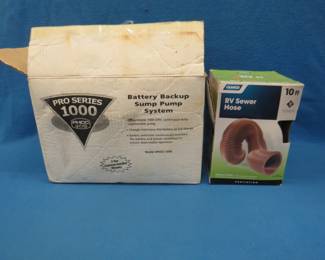 Lot 65. Battery backup sump pump system and an RV sewer hose. Both are new in the box.