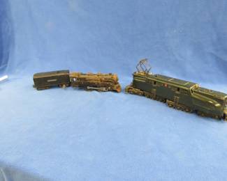 Lot 424. Three old railroad cars: Lionel Pennsylvania Railroad 20-wheel locomotive #2332 that works. Unnamed locomotive marked 391 that works. Lionel thought to be a vintage prewar tinplate tender car. Works.