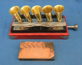 Lot 373. Antique Hohner Hohnerette 5-horn blow harmonica and an extremely rare copper photoengraved Hohnerette plate for printing. Owner has installed new leathers. 