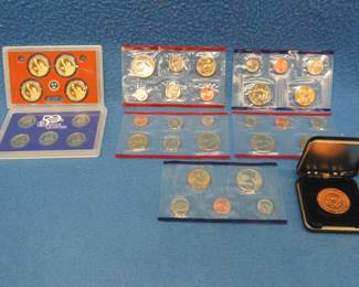 Lot 312. Coin sets: US Mint Sets: 2000 P, 2001 P, 2002 P, 2004 D, 2005 D. 2003 State Quarter set. Four Presidential gold-colored $1.00 coins. Copper White House medallion.