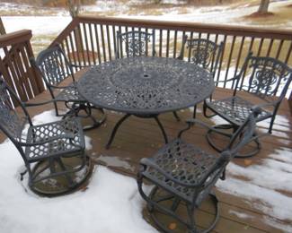 Lot 479. Heavy metal patio table, umbrella with stand, and six chairs.
