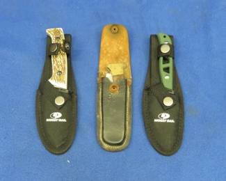 Lot 452. Three knives, two fixed-blade and one folder all have a sheath