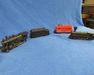 Lot 423. Four collectible train cars: Lionel locomotive #8300 that works plus a Lionel coal car stamped 6466W. Marx locomotive. Lionel electric locomotive #520 that works.