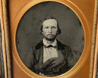 1/6 plate of man holding a kepi with red trim on the band