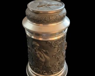 Collection of Three German Beer Steins: Relief Ceramic, Pewter-Lidded Embossed, and Cartoon-Style Ceramic