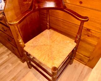 Antique wooden corner chair with rush seat often referred to as a roundabout or fireside chair