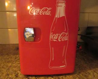 Coca Cola mini ref. Works. 12 volt or 110. I plugged it in and it got cold. Sold a collector's item, not a everyday working ref.