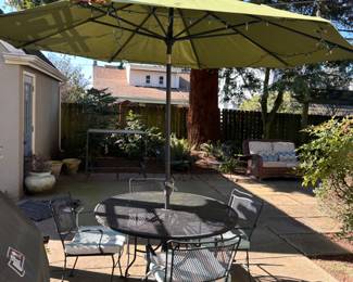 $380. Metal outdoor table with 6 chairs. 48" dia x 29"h. Green Sunbrella market umbrella 9' 7" sold separately for $70.