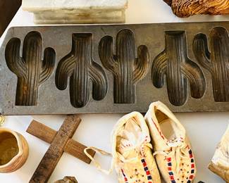 Cast cactus molds, wooden crucifix, and child moccasins, Native American