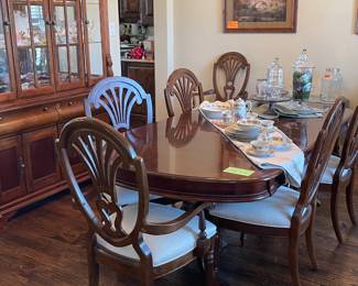 Lovely cherry finish dining table. Includes 6 chairs - 2 arm, 4 side. Also has 2 leaf extensions and custom table pad.