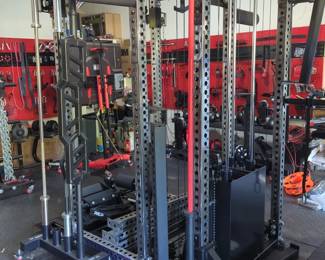 Lot 33:REP PR-5000 ARES. Massive home gym system. Hundreds of components. Please see all pictures. Manufactured by REP in clear coat. Includes main post structure, and all accessories shown in the picture is. Also includes all of the wall mount shelving and the diamond plate rubber fatigue mats covering the entire garage floor. A must-see. Please inspect! High bidder must have the ability to disassemble and remove from service. See all photos! Includes owner's manual and additional parts not shown