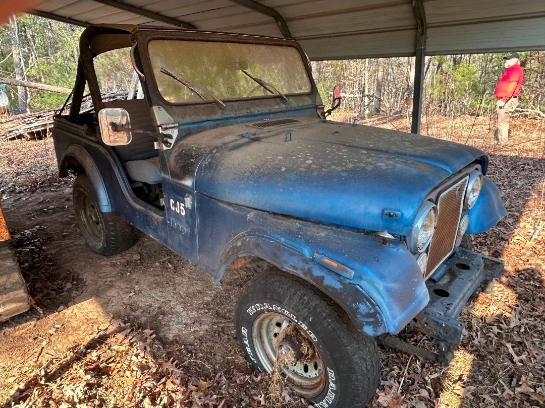{possibly a 1981} Jeep CJ-5 has been stored outdoors under this metal cover. No title. Taking Bids