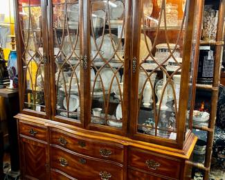 Lighted break front cabinet by Basset