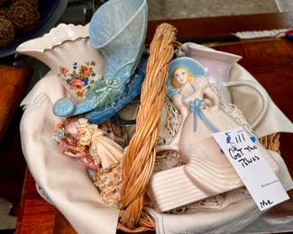 Basket of vintage porcelain figurines, vases, Roseville pottery, vintage dinner napkins, and more