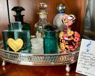 Collection of perfume and cologne bottles on a footed silver plate tray