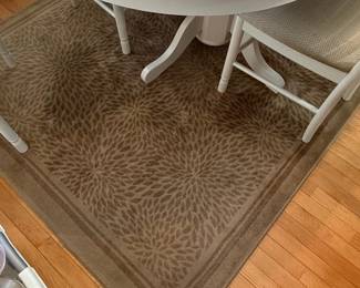 Round Oak Dining Table with White Pedestal Base and Floral Pattern Rug