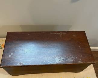 D65 - $45. *Small* Antique Wooden Chest on Wheels. Measures 25" wide x 11" deep x 11.5" tall. Top has some damage to the finish but it is solid wood. 