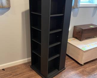 D66 - $40. Spinning storage cabinet. Measures 18.75" square x 50" tall. Black finish. Does have some chips in the veneer. Shelves are adjustable for books or CDs/DVDs. 