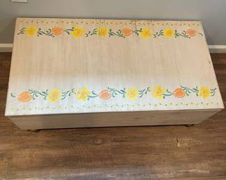 D64 - $30. Wooden Toy Storage Box on Wheels. Measures 44" wide x 23.25" deep x 14.5" tall. Stenciled floral top. Does NOT have safety hardware!