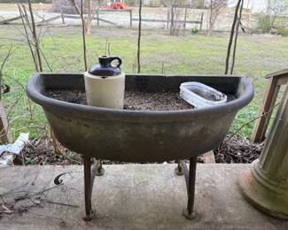 Cast iron sink--(used as a planter) (crock jug is broken)