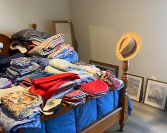 A full bed of linens, artwork, beautiful vintage bedframe