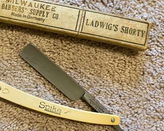 a Union Cutlery Co. "Spike" straight razor, produced in Germany and distributed by Milwaukee Barbers Supply Co. It features a celluloid handle and comes with its original cardboard box marked "Ladwig's Shorty"