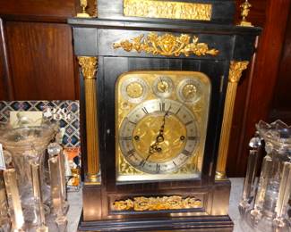 This Very large and Heavy as an o ld Steel Buick is an Antique Bracket Clock ebonized and adorned w/ gold Omolu by Smith and Son, London  from about 1860 (it gongs, cvhimes rings, bells and a little tune) it is flanked by a pair of  clear lusters w/ extremely long spear point prisms