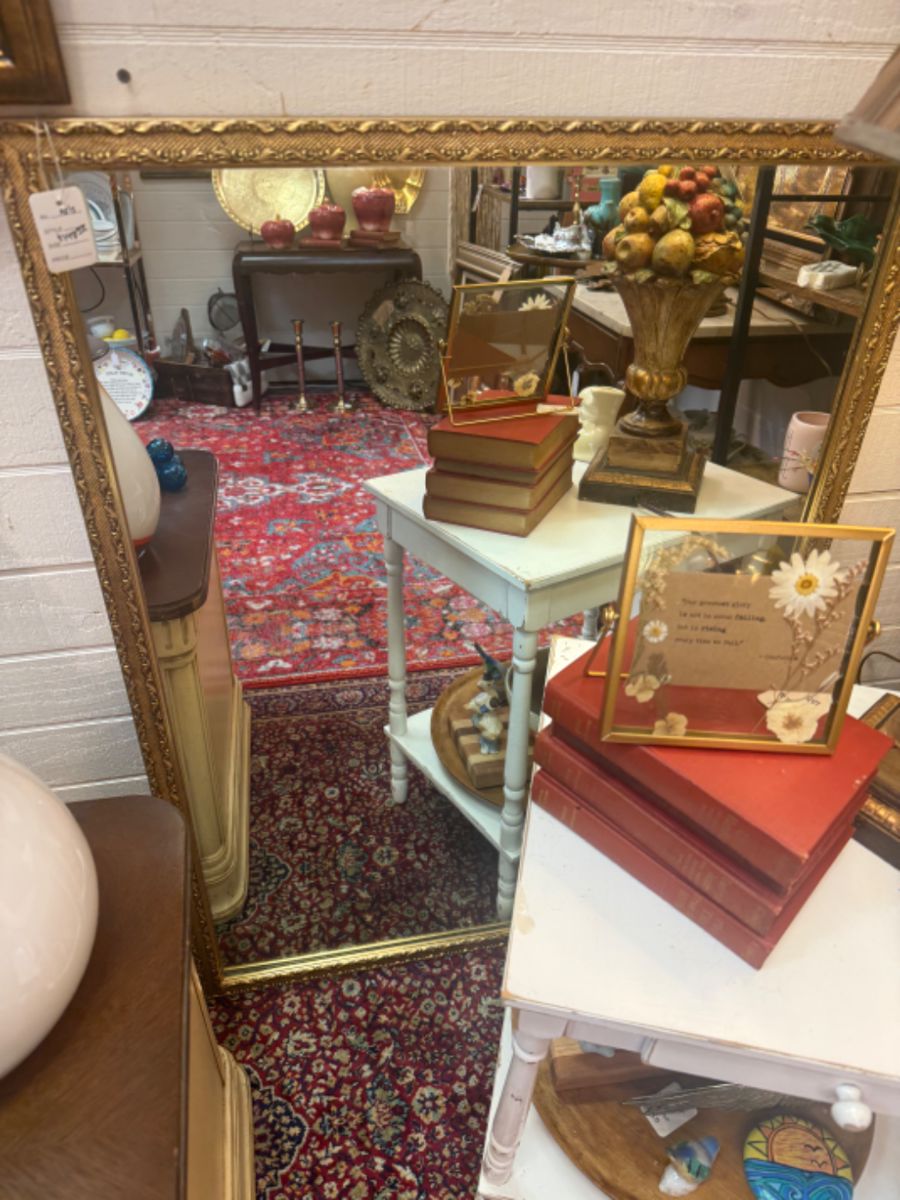 Beautiful gold framed wall mirror, vintage books, end table