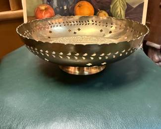 Decorative collectible brass bowl with intricate etchings, cut-out patterns along the rim
