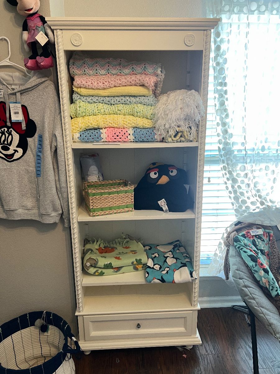 Shabby chic white bookshelf with baby crocheted blankets
