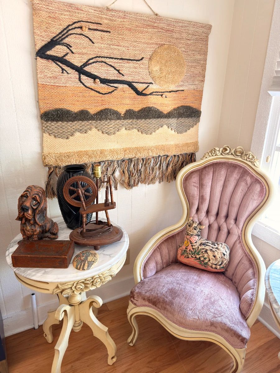 Vintage pink velvet Victorian parlor chair, antique spinning wheel, woven wall hanging