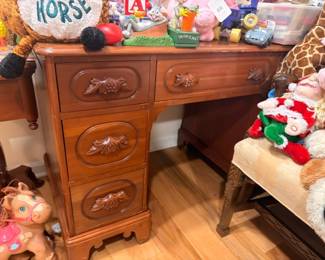 Dark wood desk with brass pulls, stuffed animals, toy giraffe, children's items