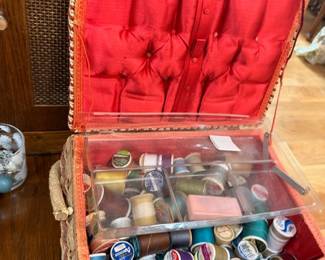 Vintage wicker sewing basket with red satin lining, thread, buttons, sewing notions