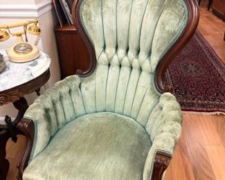 Victorian green velvet tufted parlor armchair with carved dark wood frame