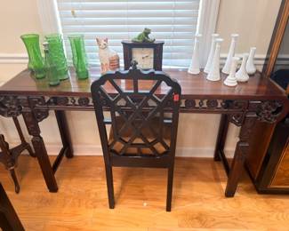 Dark wood console table with fretwork, green glass vases, white milk glass vases