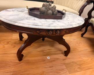 Victorian marble-top oval coffee table with carved dark wood cabriole legs