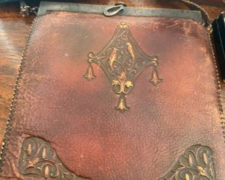 Antique tooled leather purse with ornate brass clasp