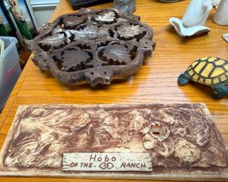 Cast iron decorative trivet, marble cutting board, ceramic turtle figurine, ranch sign