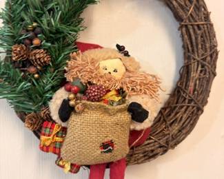 Christmas grapevine wreath with greenery, pinecones, and elf figurine