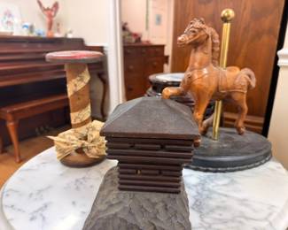Carved wooden carousel horse figurine on decorative pedestal base