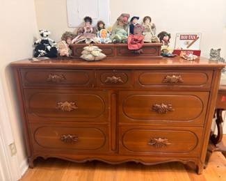 Dark wood buffet dresser with brass pulls, collectible dolls and stuffed animals