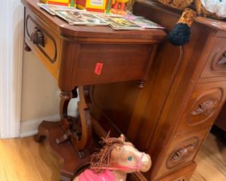 Wooden desk with vintage children's toys, books, toy horse, and collectibles