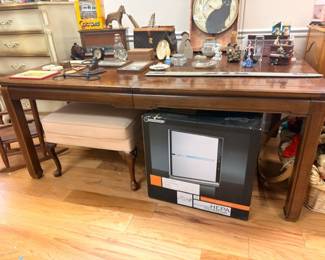 Large wood library table desk with collectible figurines, vintage CRT TV, household items