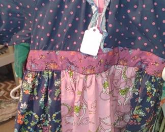 Matilda Jane Walden Wishes apron dress features a patchwork design with navy polka dot fabric and floral patterns. 