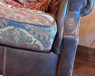 leather wing chair-and-a-half with a paisley fabric seat cushion and nailhead trim, by King Hickory.