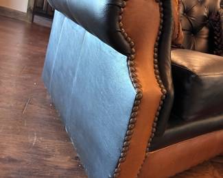 classic curved western-style leather sofa featuring a tufted seat back and saddle tan leather accents